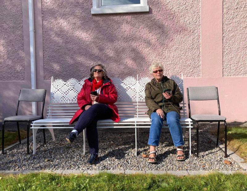Marina Postir (L) and Teresa Eagleton (R) listening to the audio walk on their headphones, outside the library in Headford